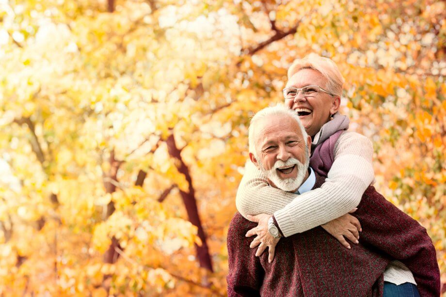 older happy couple outside in the fall