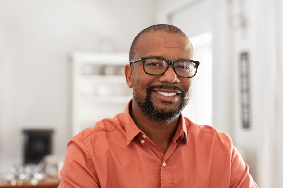 smiling man in orange Oxford shirt