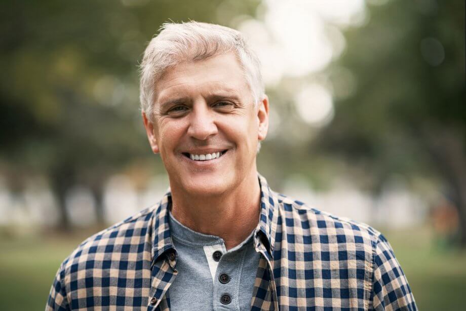 smiling older man standing outside