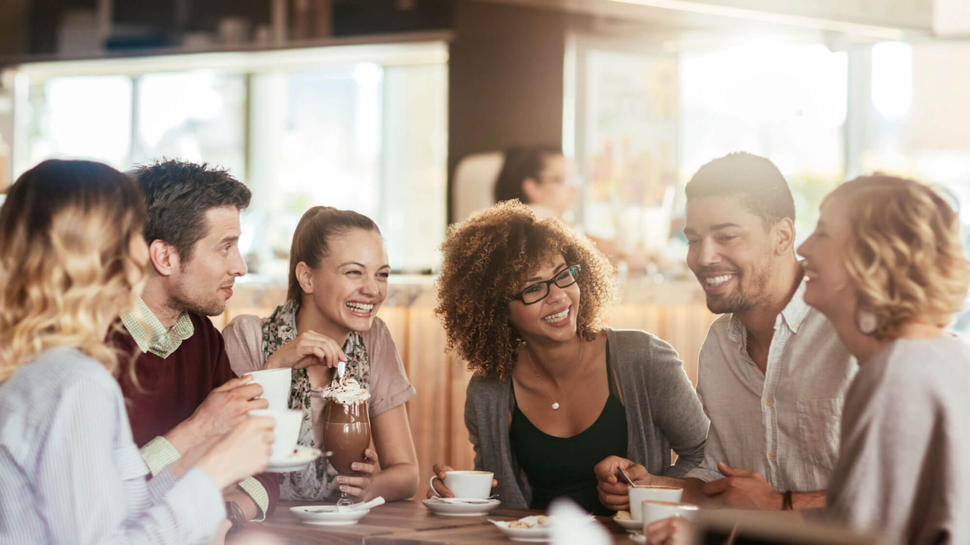 friends sitting around a restaurant table having coffee