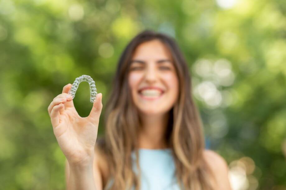 woman holding up dental aligner